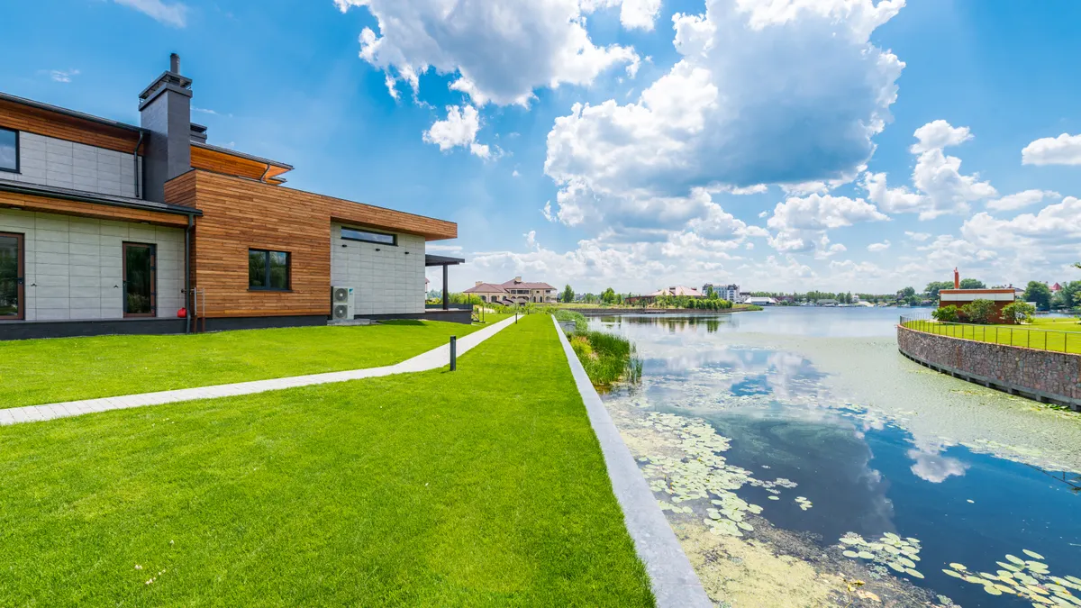 house and lawn beside a water edge