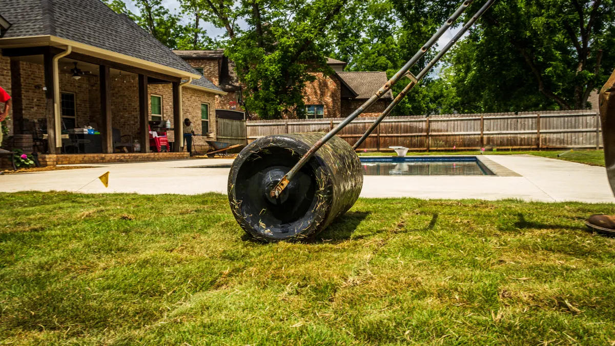 Person rolling a lawn to smooth and level the surface