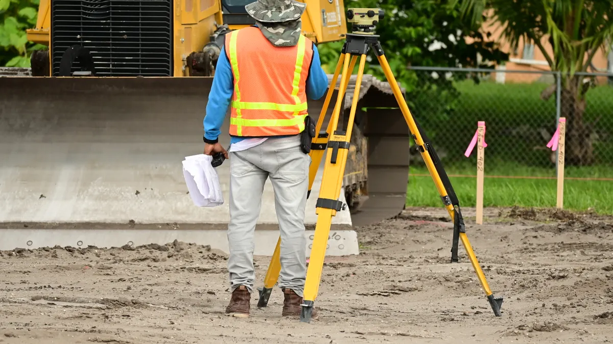 How to Mark Surface Water Flow Paths in a Yard After Rain Surveying setup on a dirt worksite